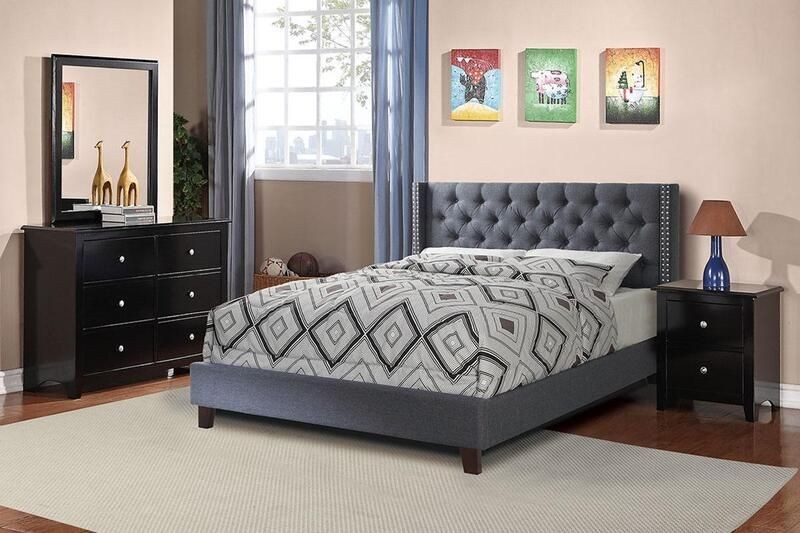 Modern bedroom with a dark upholstered bed, geometric bedding, and black furniture with decorative accents.